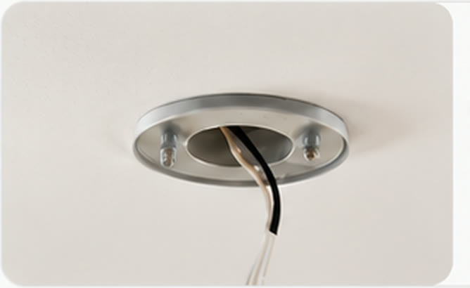 An existing ceiling rose with its wiring exposed.